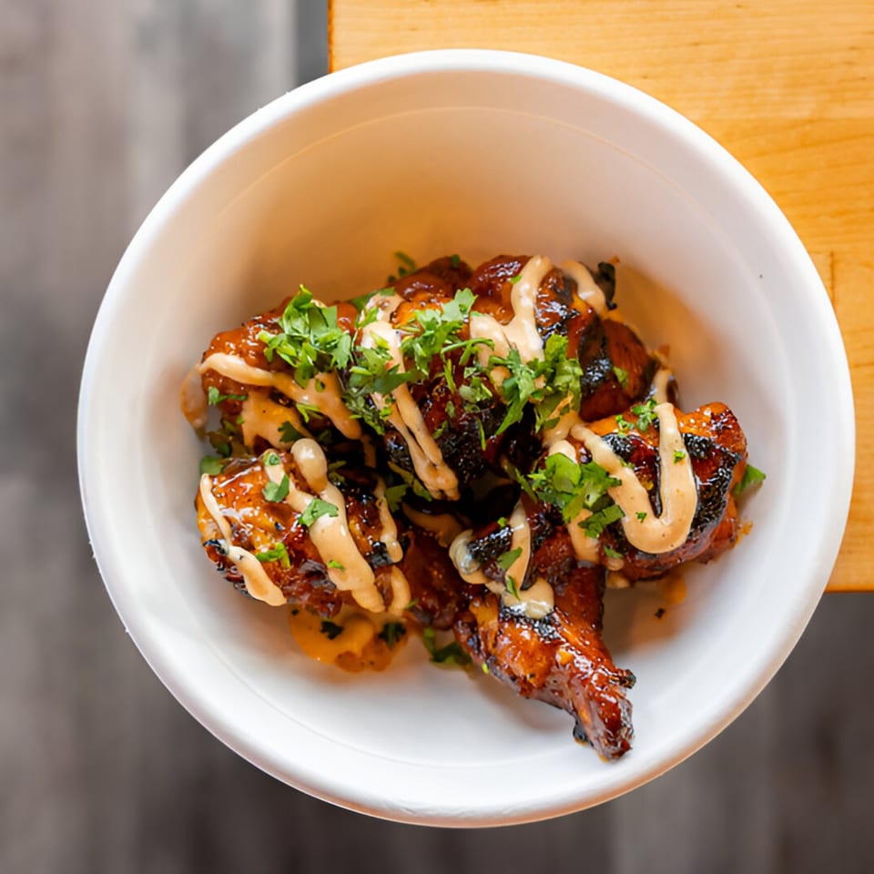 El Jefe's Grill Mexican BBQ wings, glazed and drizzled with sauce, topped with fresh cilantro.